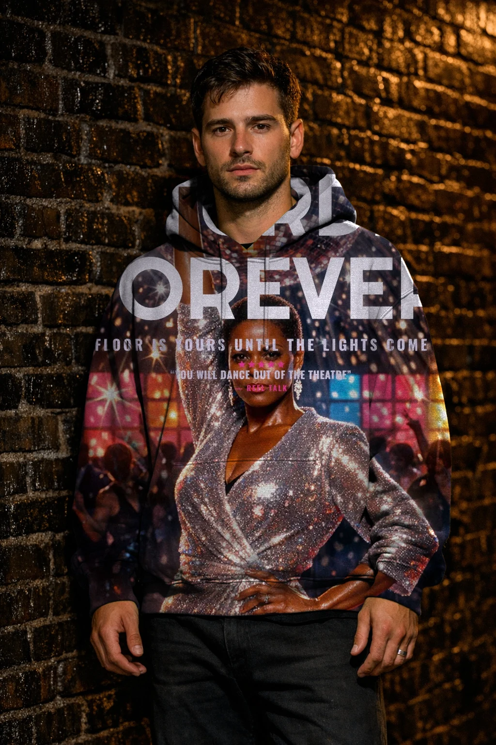 A man against a wet brick wall at night in a hoodie printed edge to edge with the Disco 1977 poster of Imani